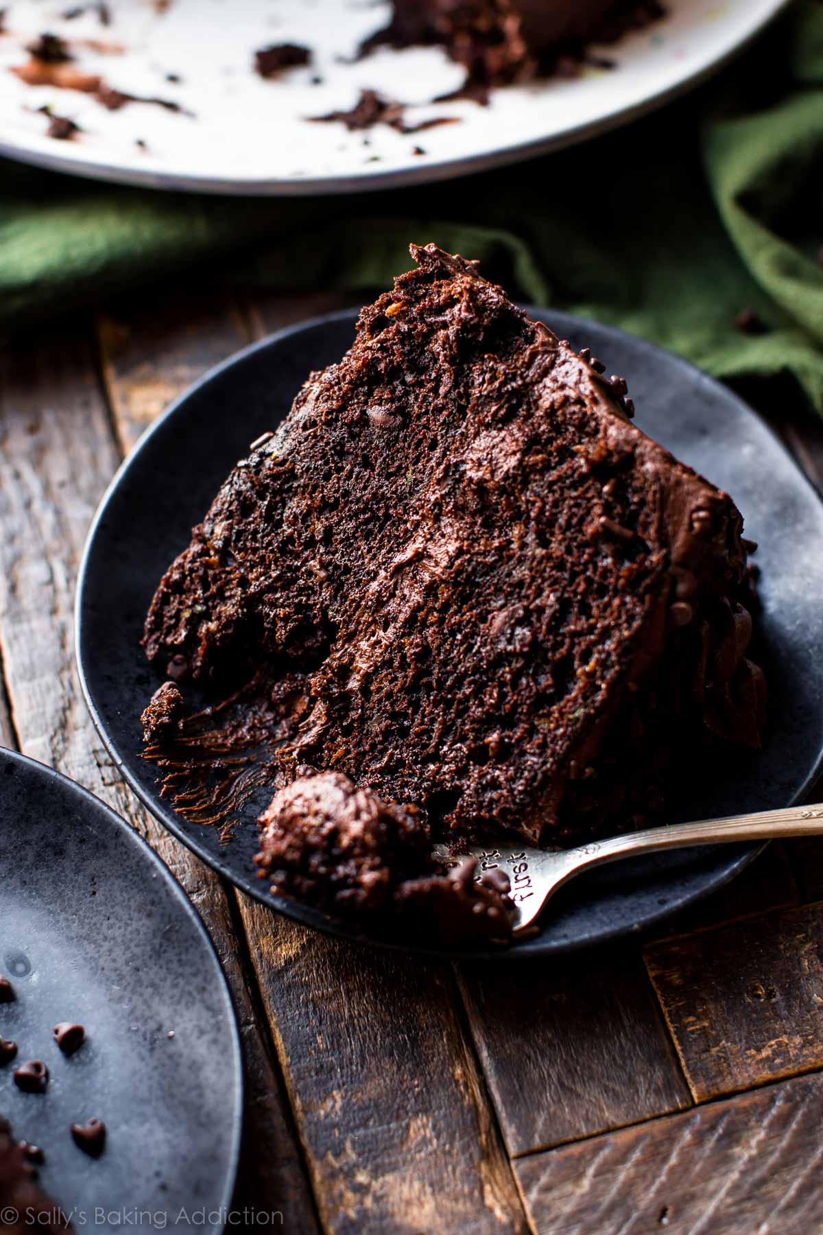 slice of chocolate zucchini cake on a black plate with a fork