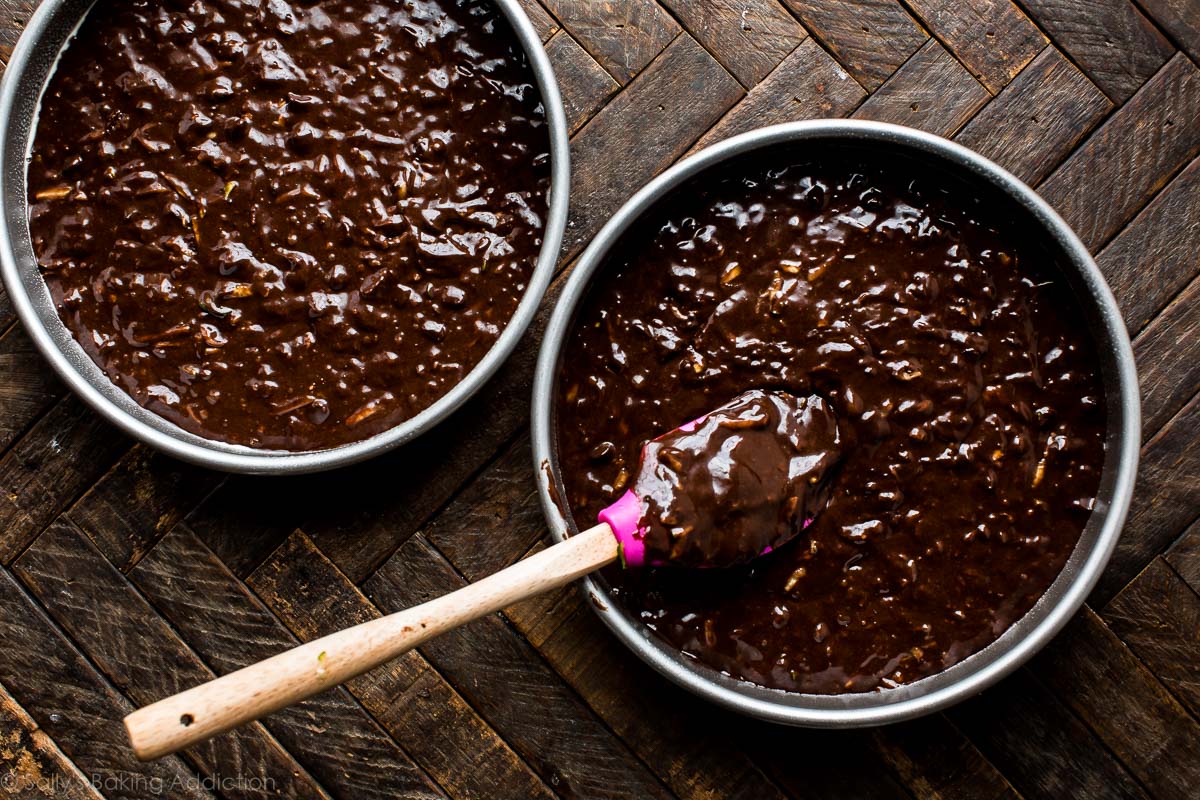 2 round cake pans filled with chocolate zucchini cake batter before baking