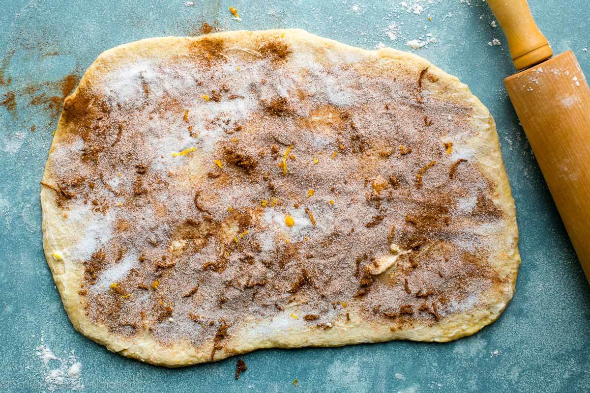 dough rolled into a rectangle topped with orange sweet roll filling