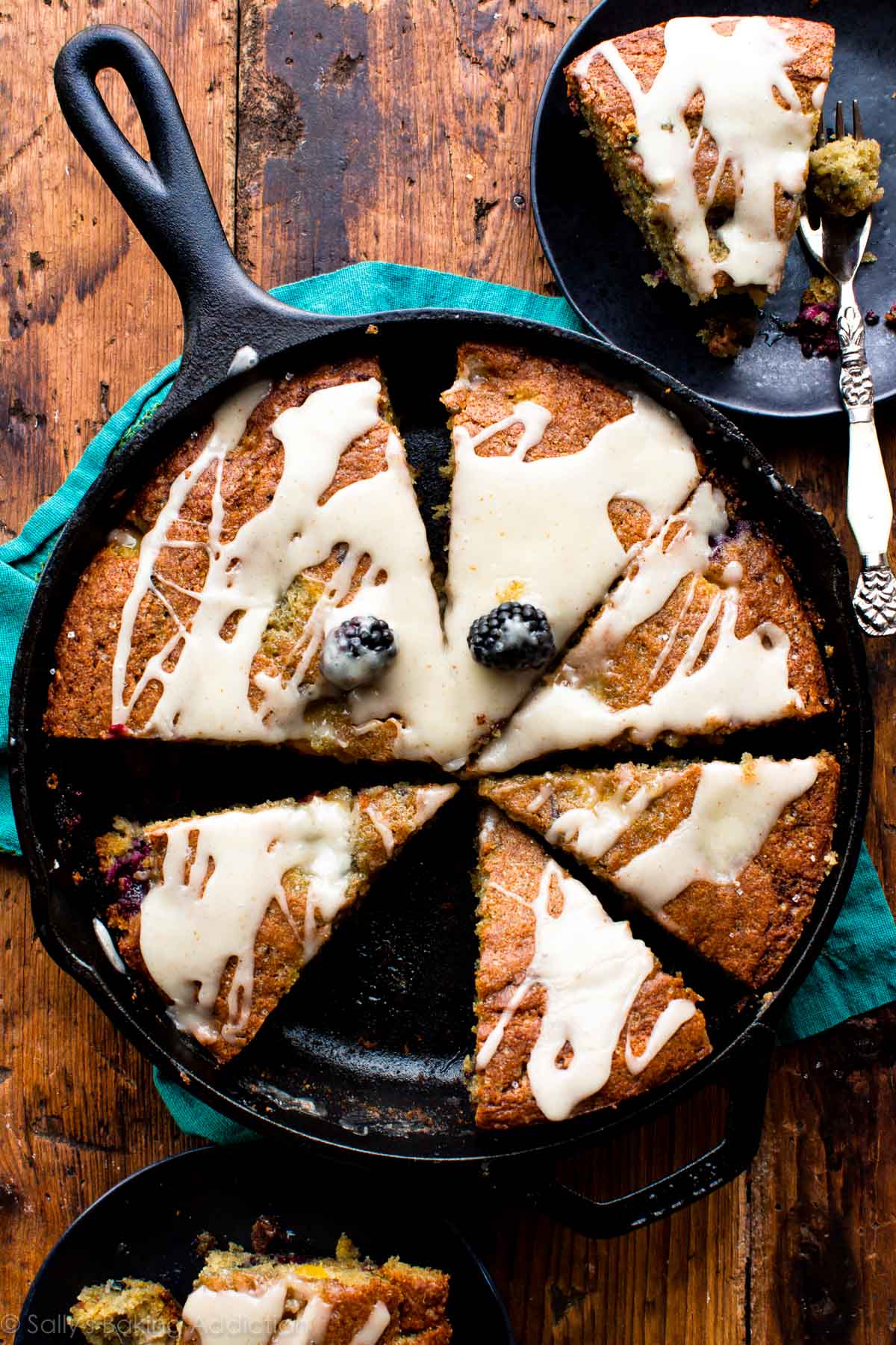 overhead image of blackberry peach skillet cornmeal cake cut into slices