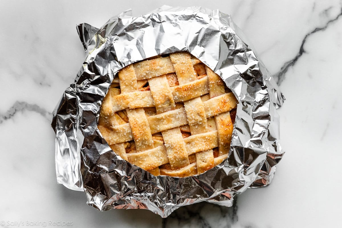 lattice pie crust top shown with aluminum foil placed just on pie's edges.