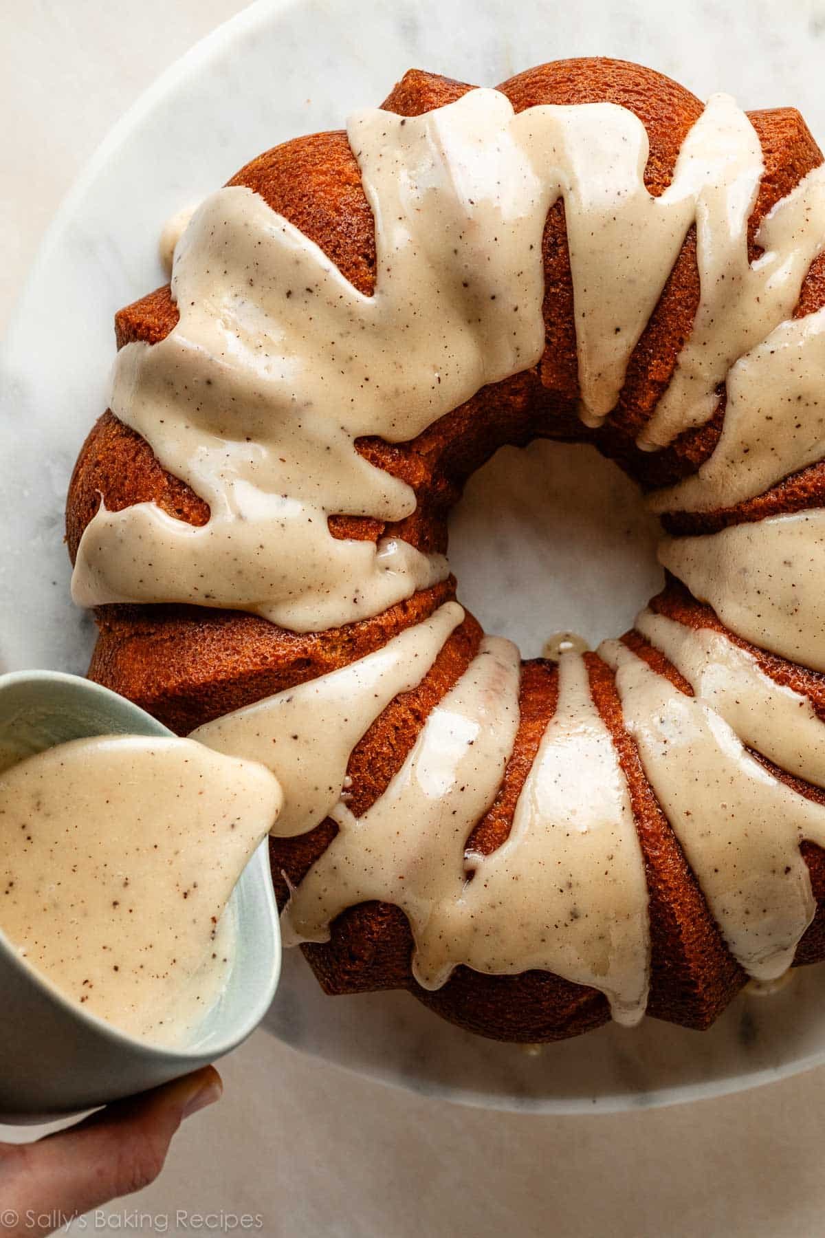 pouring brown butter icing on Bundt cake.