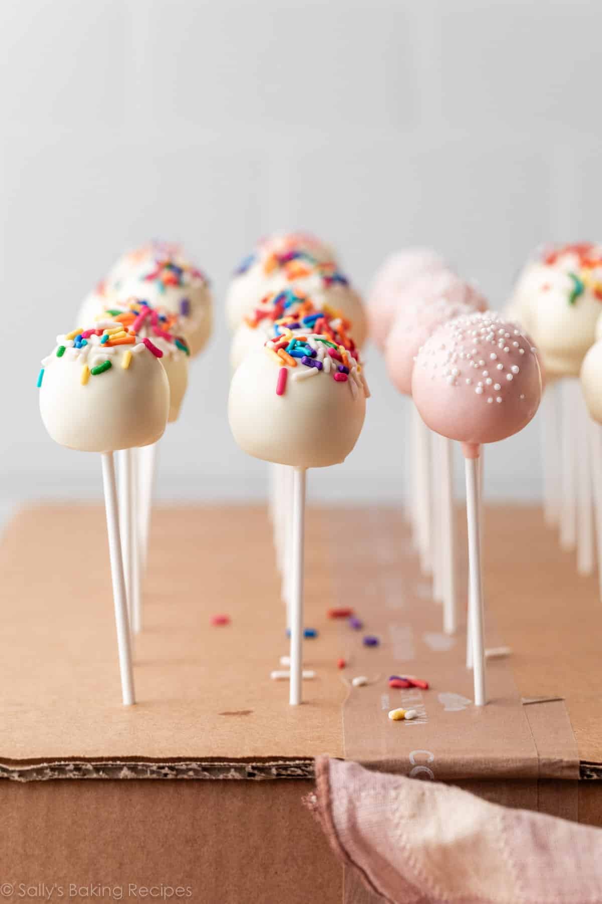 cake pops with white coating and light pink coating.