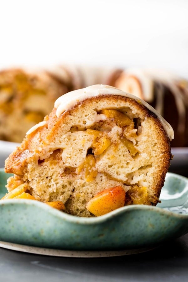 slice of peach bundt cake on a teal plate