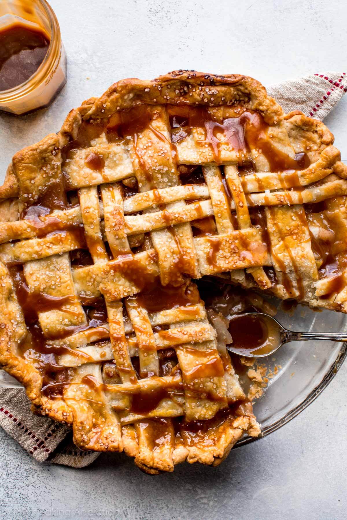 caramel pear pie in a glass pie dish with a slice removed