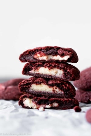 stack of cream cheese stuffed red velvet cookies showing the inside filling