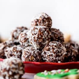 stack of no-bake chocolate coconut snowballs on a red plate