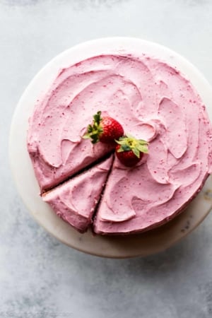 overhead image of homemade strawberry cake on a marble cake stand