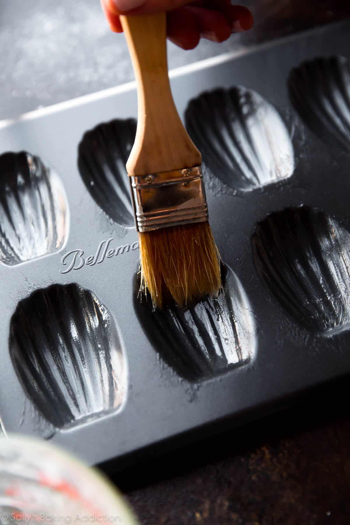 brushing madeleine pan with melted butter