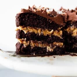 slice of German chocolate cake on a cake server on a marble cake stand