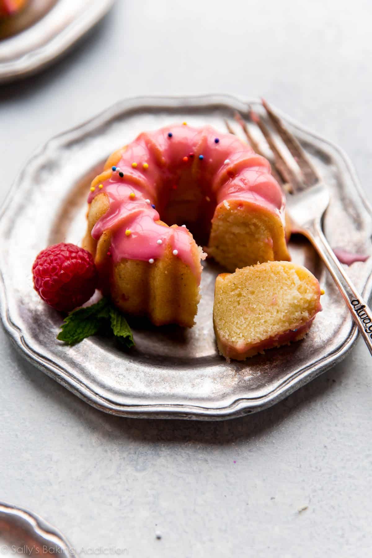 Mini pound cake with raspberry icing and sprinkles on silver plate