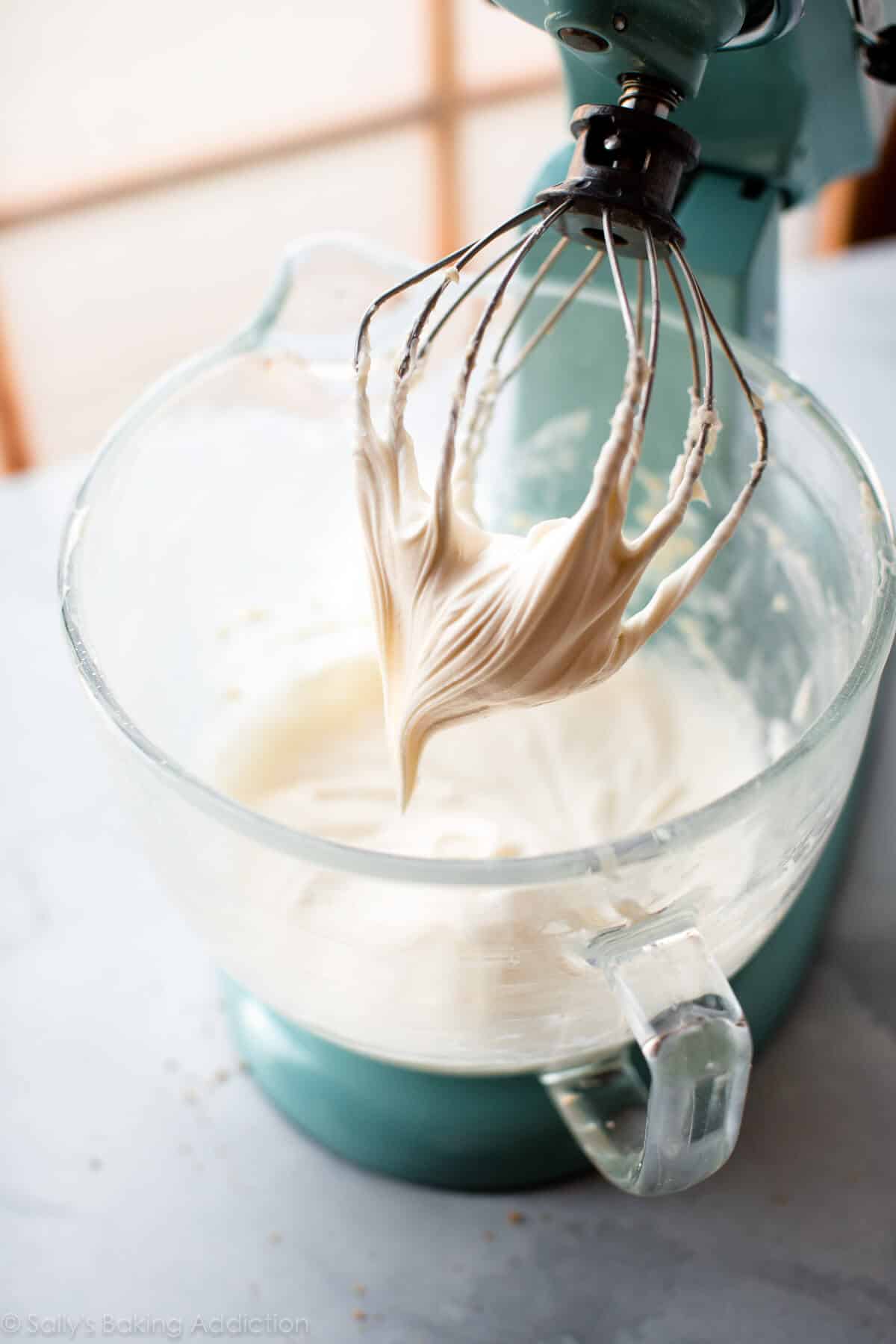 cream cheese frosting in a glass stand mixer bowl with whisk attachment