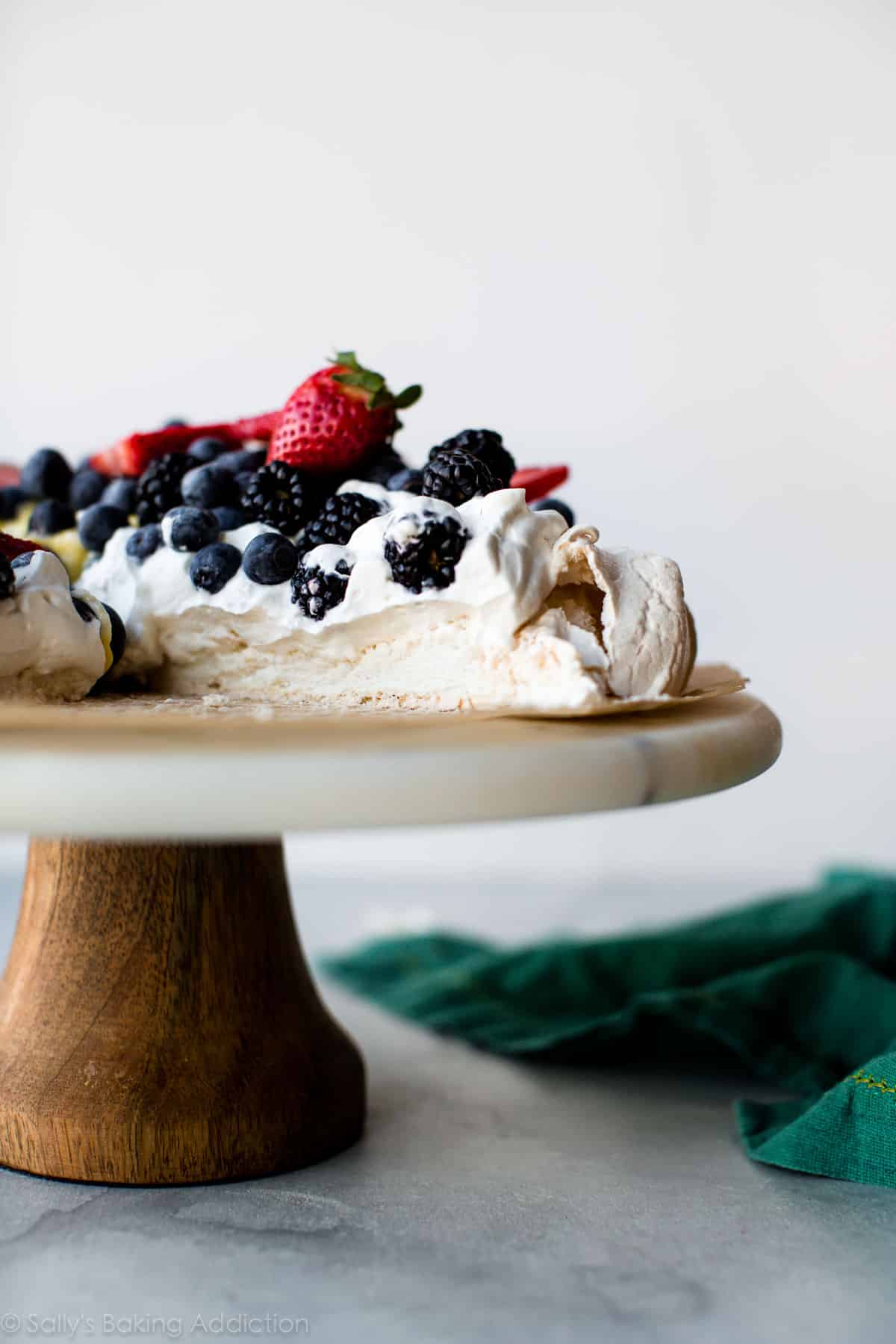 pavlova on a marble and wood cake stand