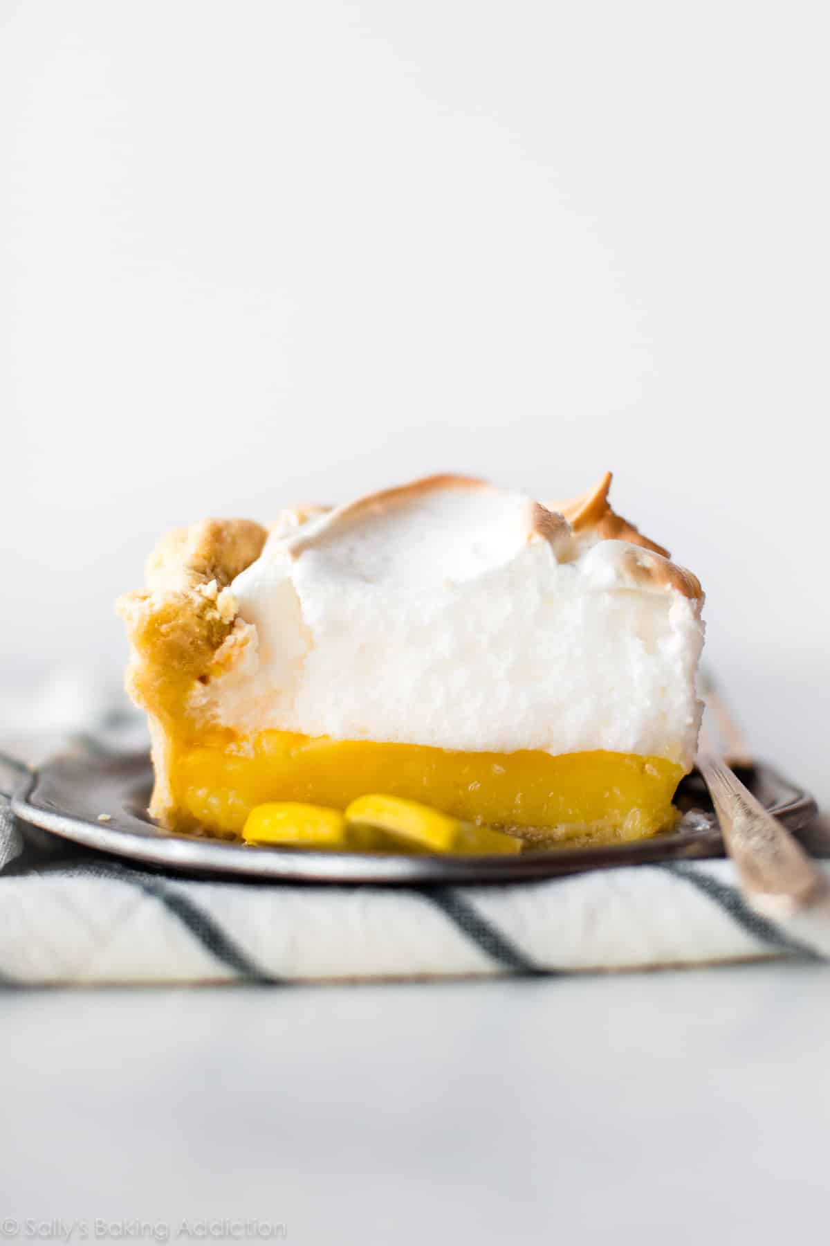 Lemon meringue pie slice on a silver plate