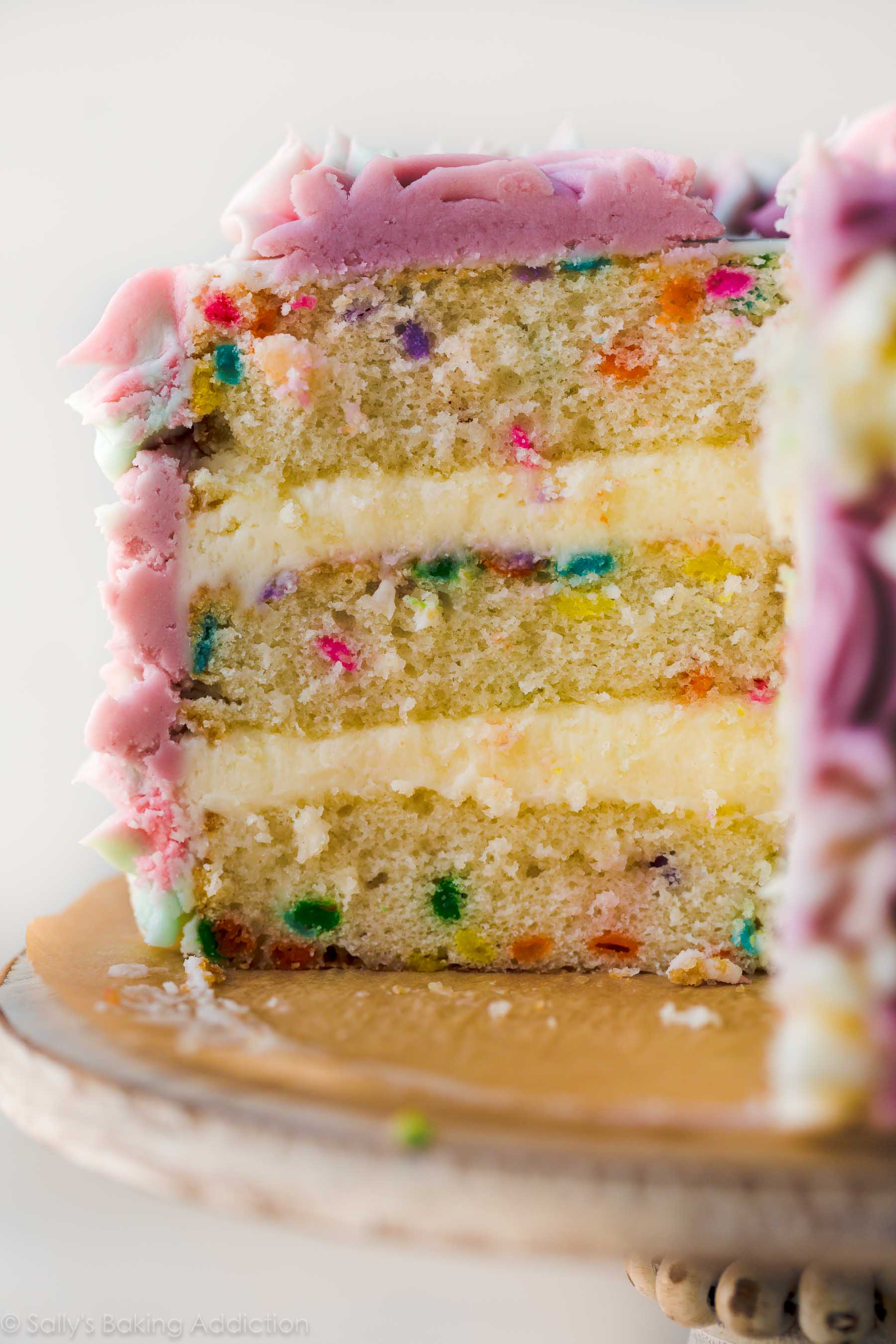 3 layer 6 inch sprinkle birthday cake with frosting on cake stand