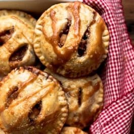 Apple hand pies in a white baking dish with salted caramel sauce