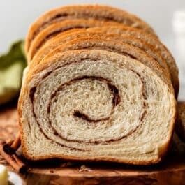 slices of homemade cinnamon swirl yeasted bread on wooden serving board.