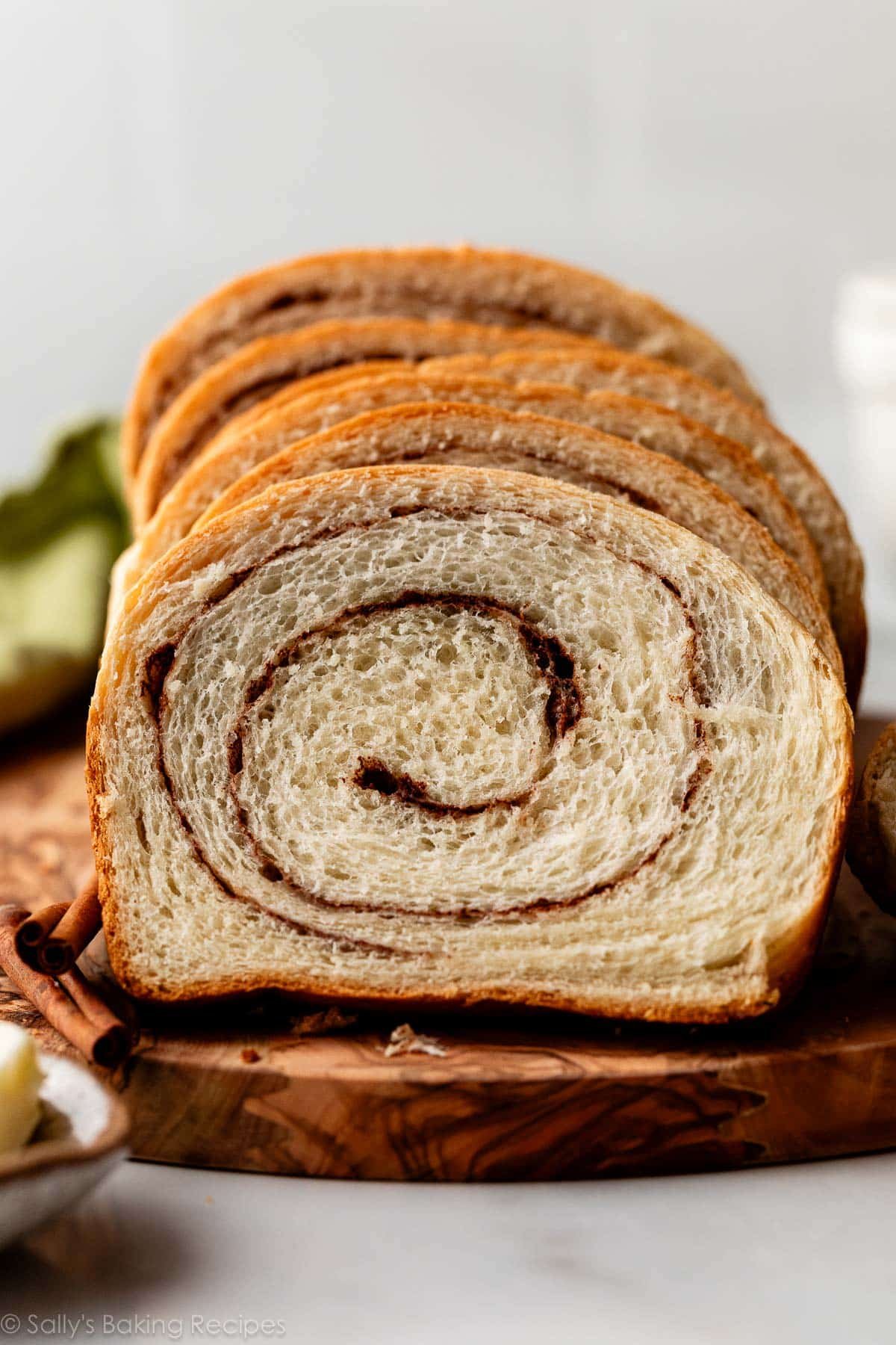 slices of homemade cinnamon swirl yeasted bread on wooden serving board.