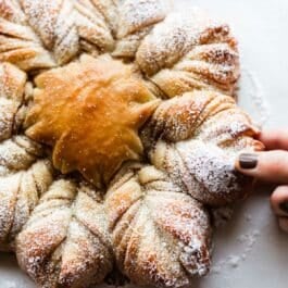 cinnamon sugar star bread with hand pulling apart a piece