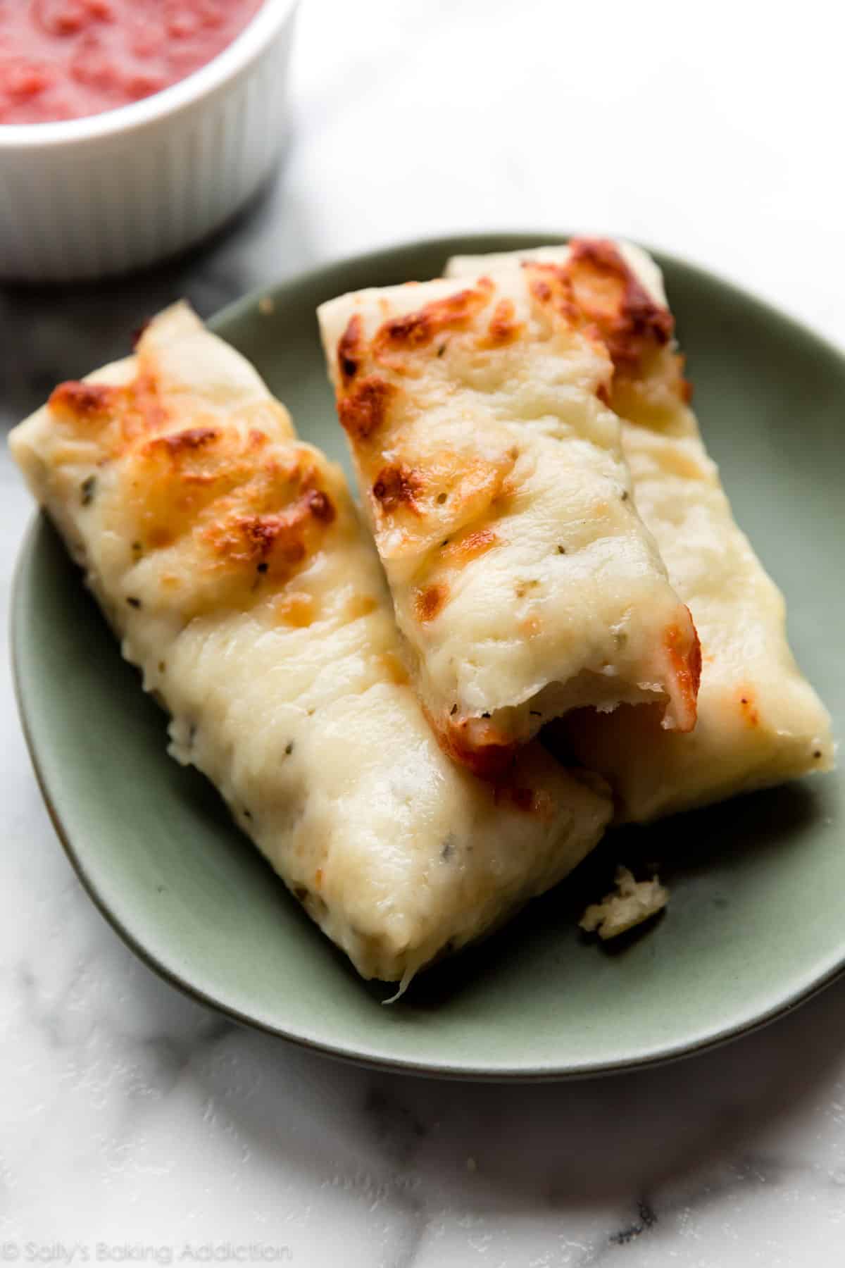 Cheese breadsticks on a green plate