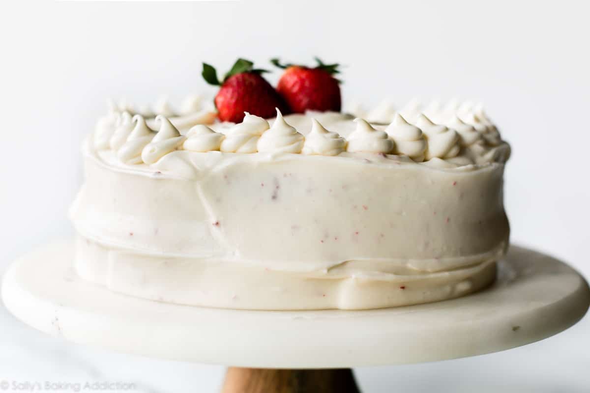 Red velvet layer cake on a marble and wood cake stand