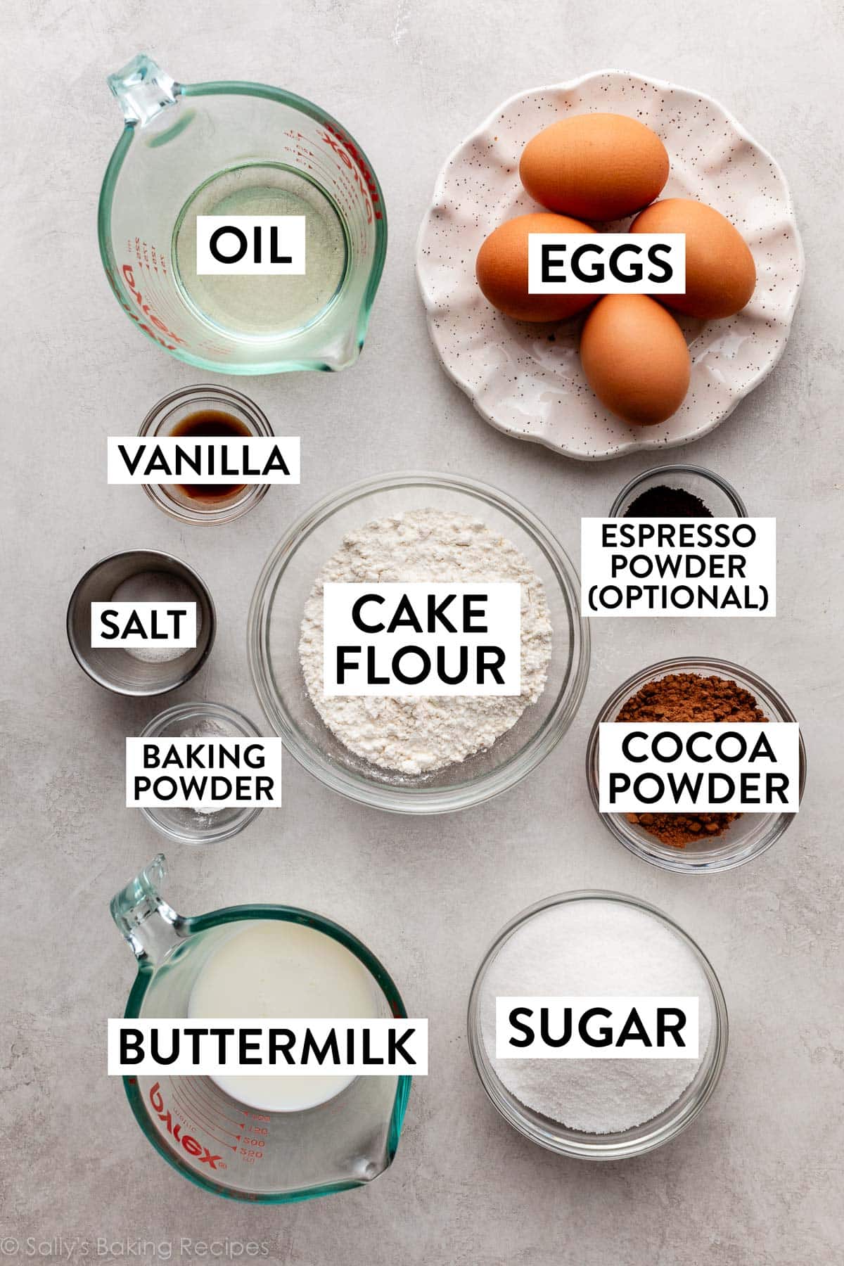 ingredients on counter including eggs, oil, cocoa powder, cake flour, buttermilk, and sugar.