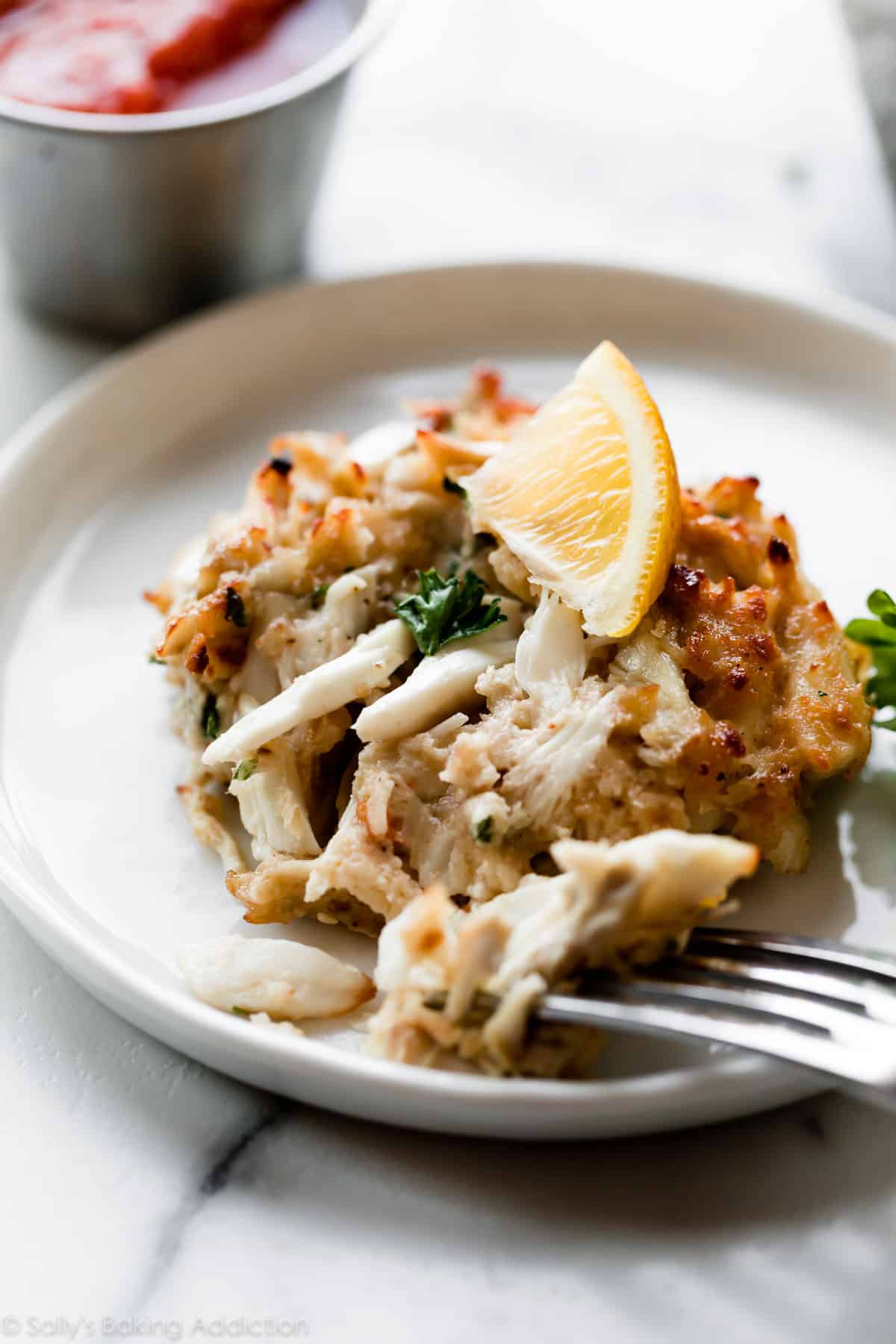 Maryland crab cake with lemon wedge on white plate