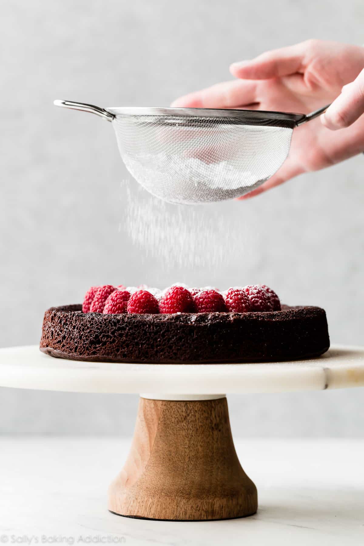 flourless chocolate cake with raspberries and powdered sugar