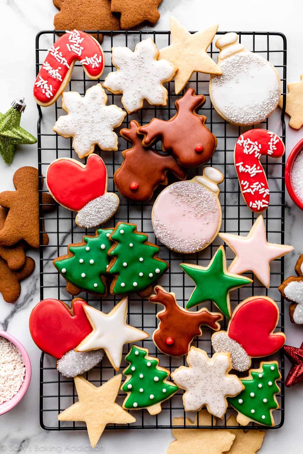 decorated sugar cookies and gingerbread cookies with colorful icing on cooling rack