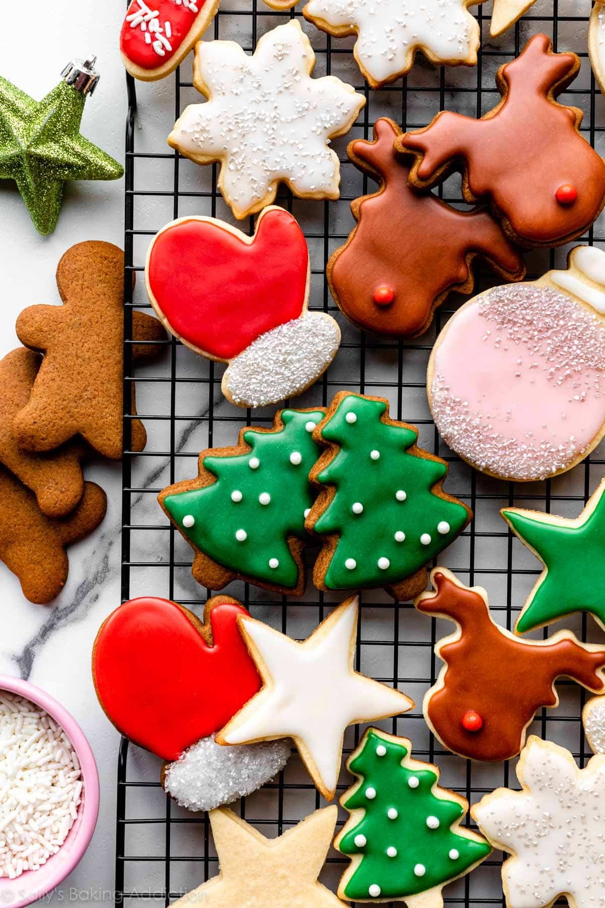 decorated sugar cookies and gingerbread cookies with colorful icing on cooling rack