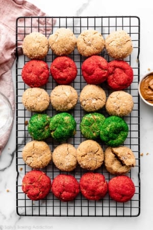 almond butter cookies rolled in white coarse sugar and red and green sanding sugar on cooling rack