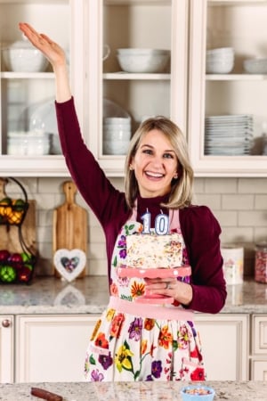 sally holding sprinkle cake with number 10 candles