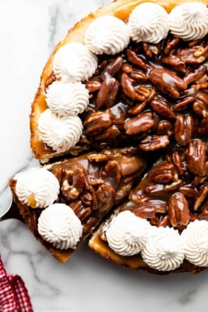 overhead photo showing a slice of pecan pie cheesecake being removed from the pan.