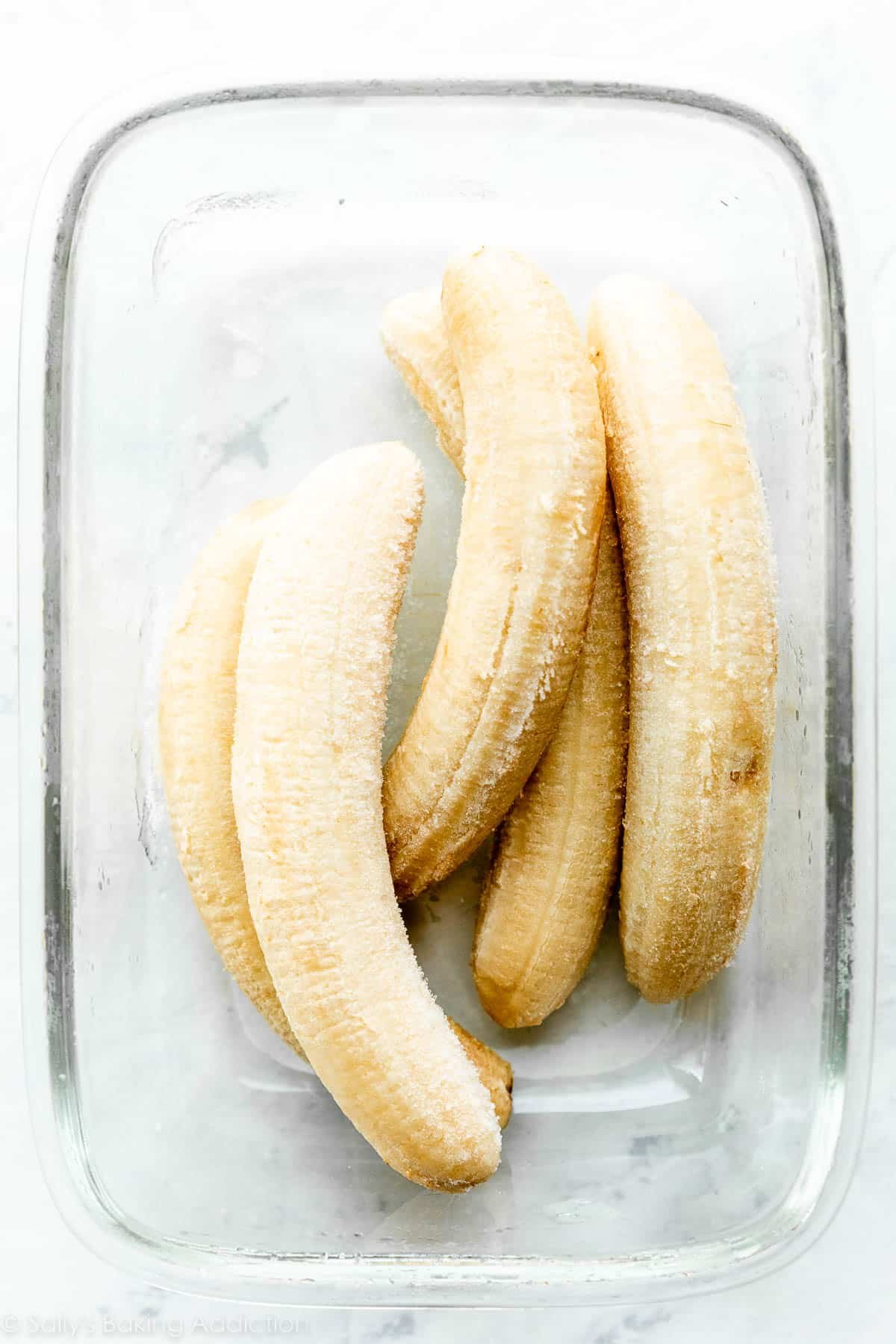 5 frozen bananas in glass rectangle container.