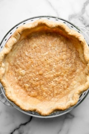 fully baked pie crust shell in glass pie dish.