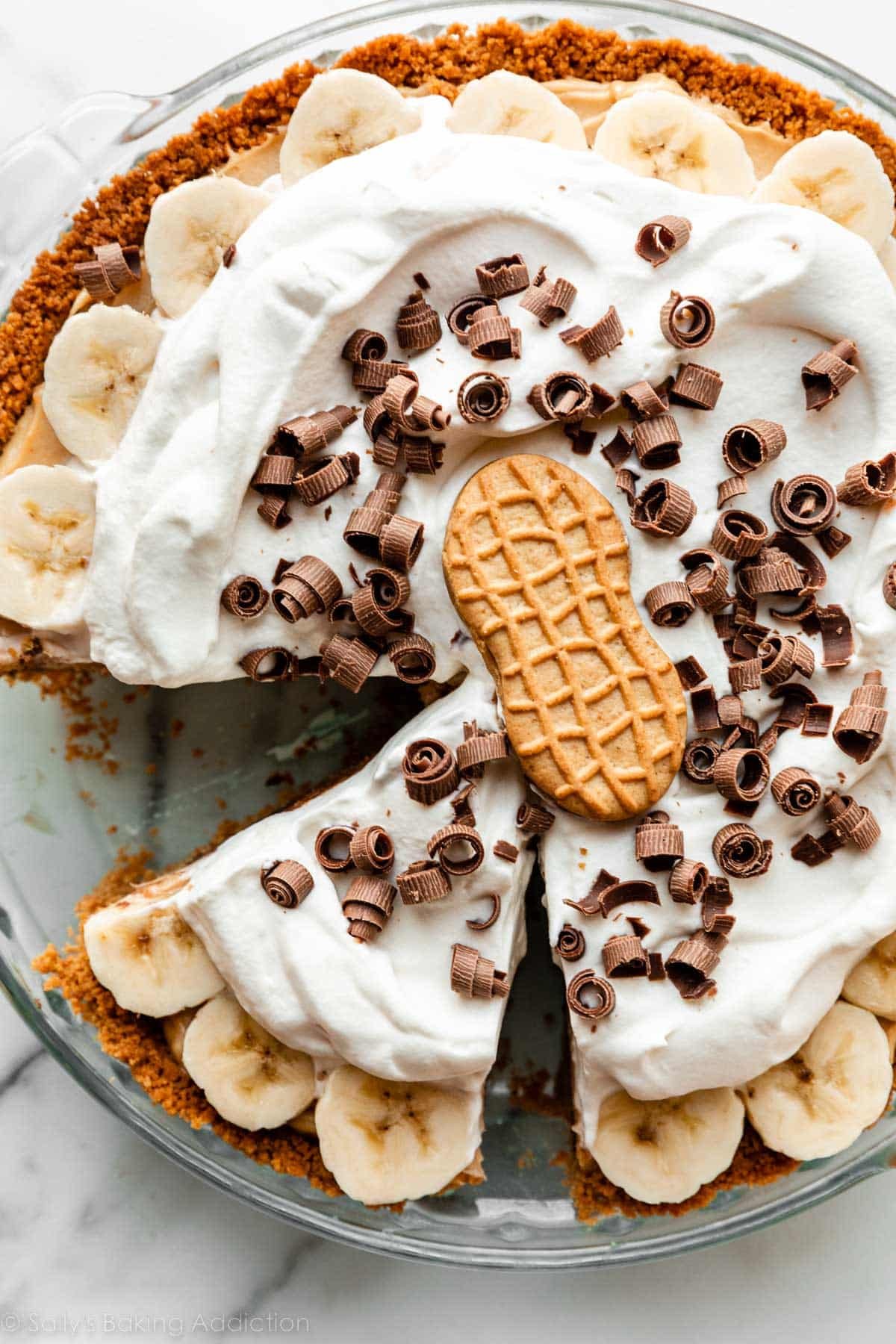 whipped cream, chocolate shavings, and Nutter Butter cookie on top of banana slices and peanut butter pie.