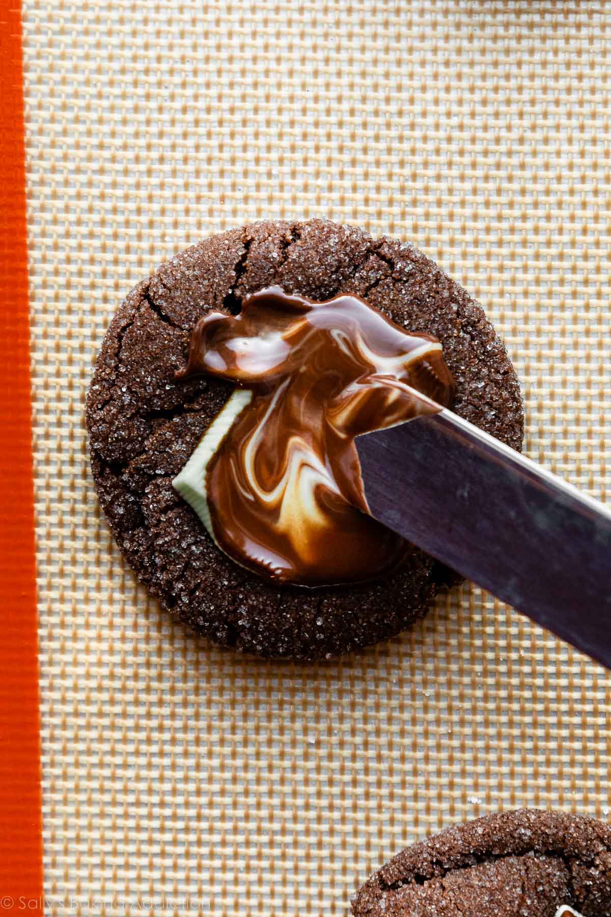 photo showing spreading the melted mint candy on top of a cookie.