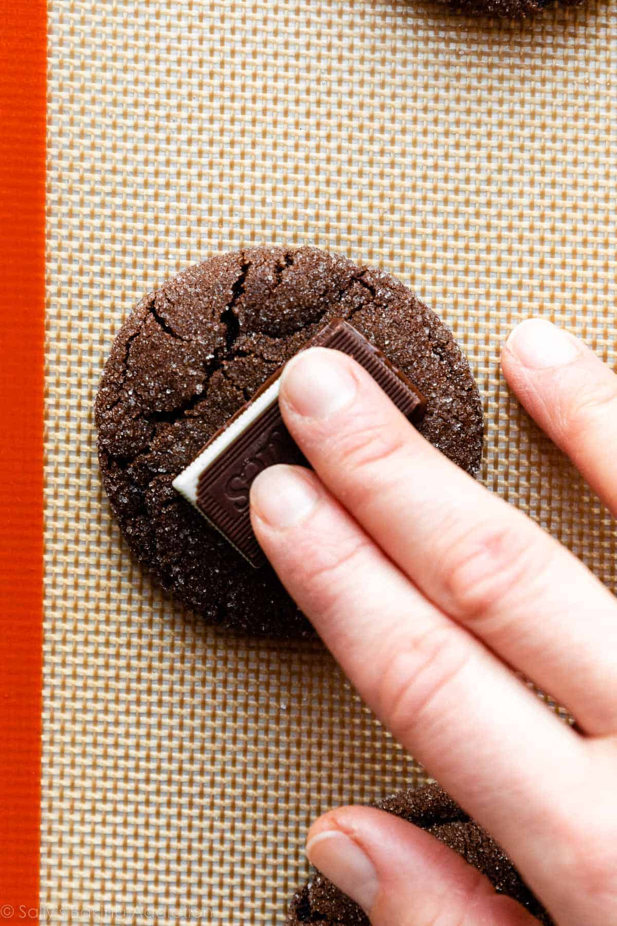 hand pressing Andes chocolate mint on top of a cookie.