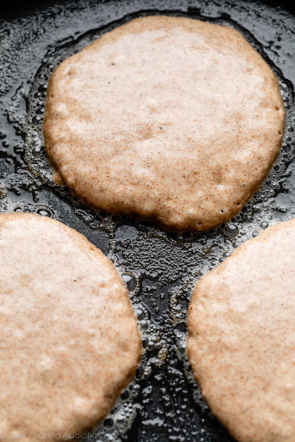 pancakes being cooked on griddle.