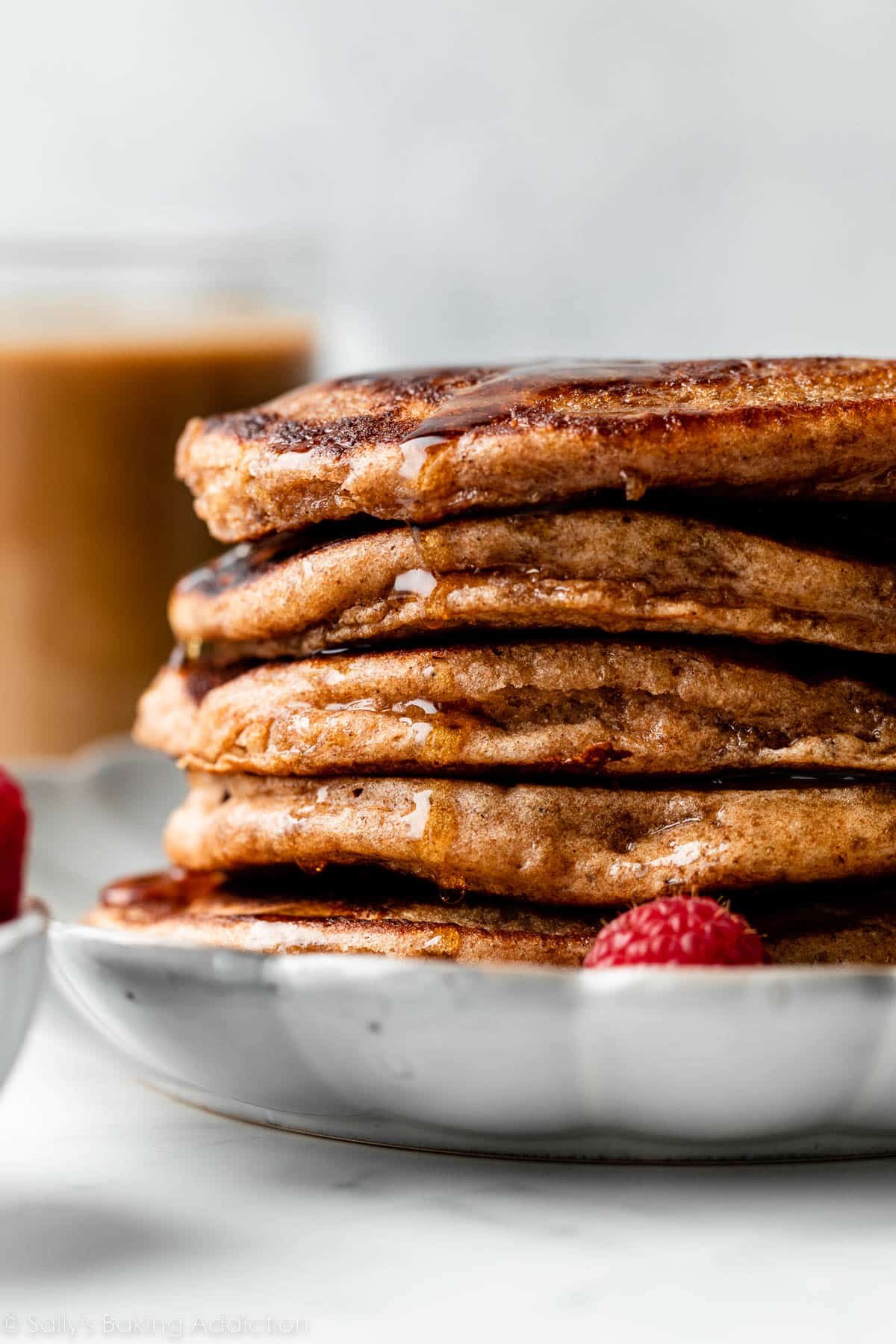 stack of whole wheat pancakes with maple syrup dripping down.