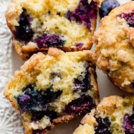 lemon blueberry muffin cut in half to show blueberries in center.