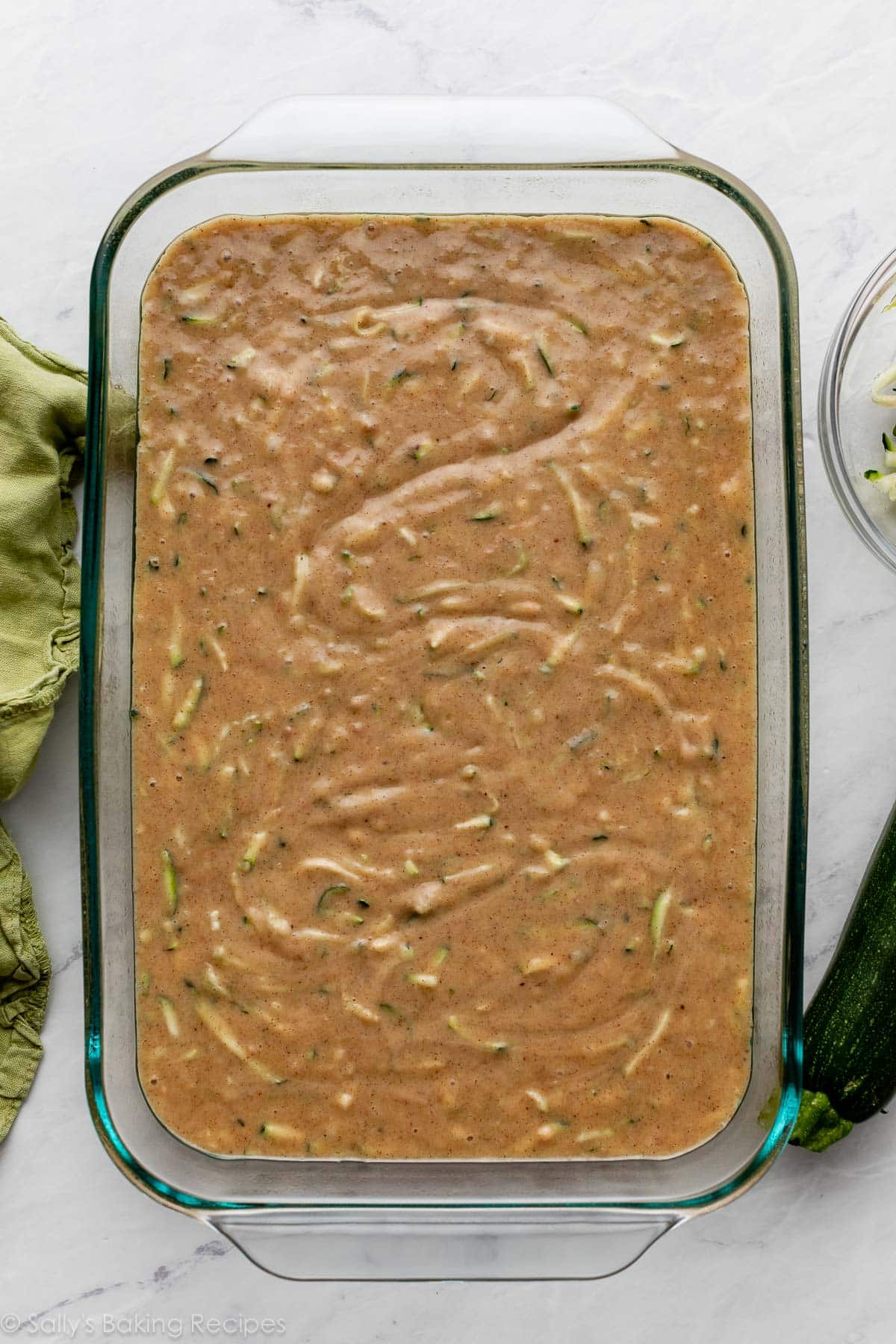 zucchini batter spread in a glass pan.