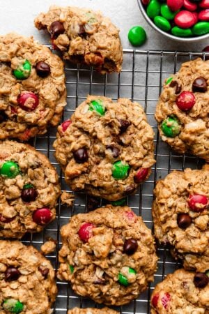 flourless Christmas-colored M&M monster cookies on wire cooling rack.