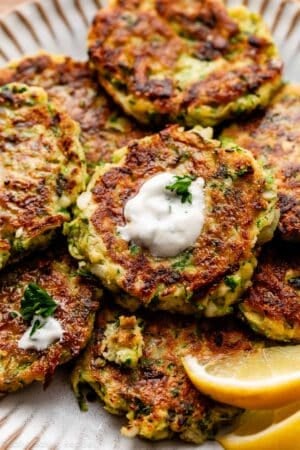 close-up of zucchini fritters with garlic herb Greek yogurt sauce.