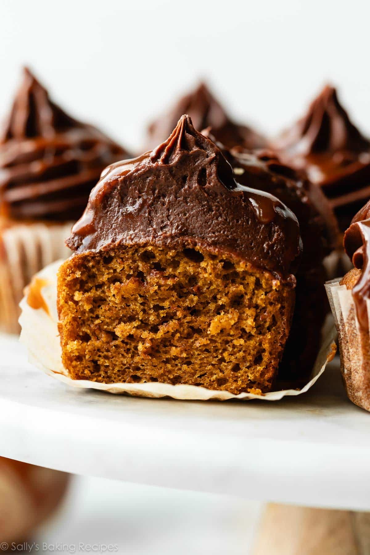 pumpkin cut in half with chocolate buttercream on top.