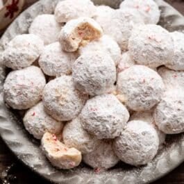 peppermint candy cane snowball cookies in gray dish.