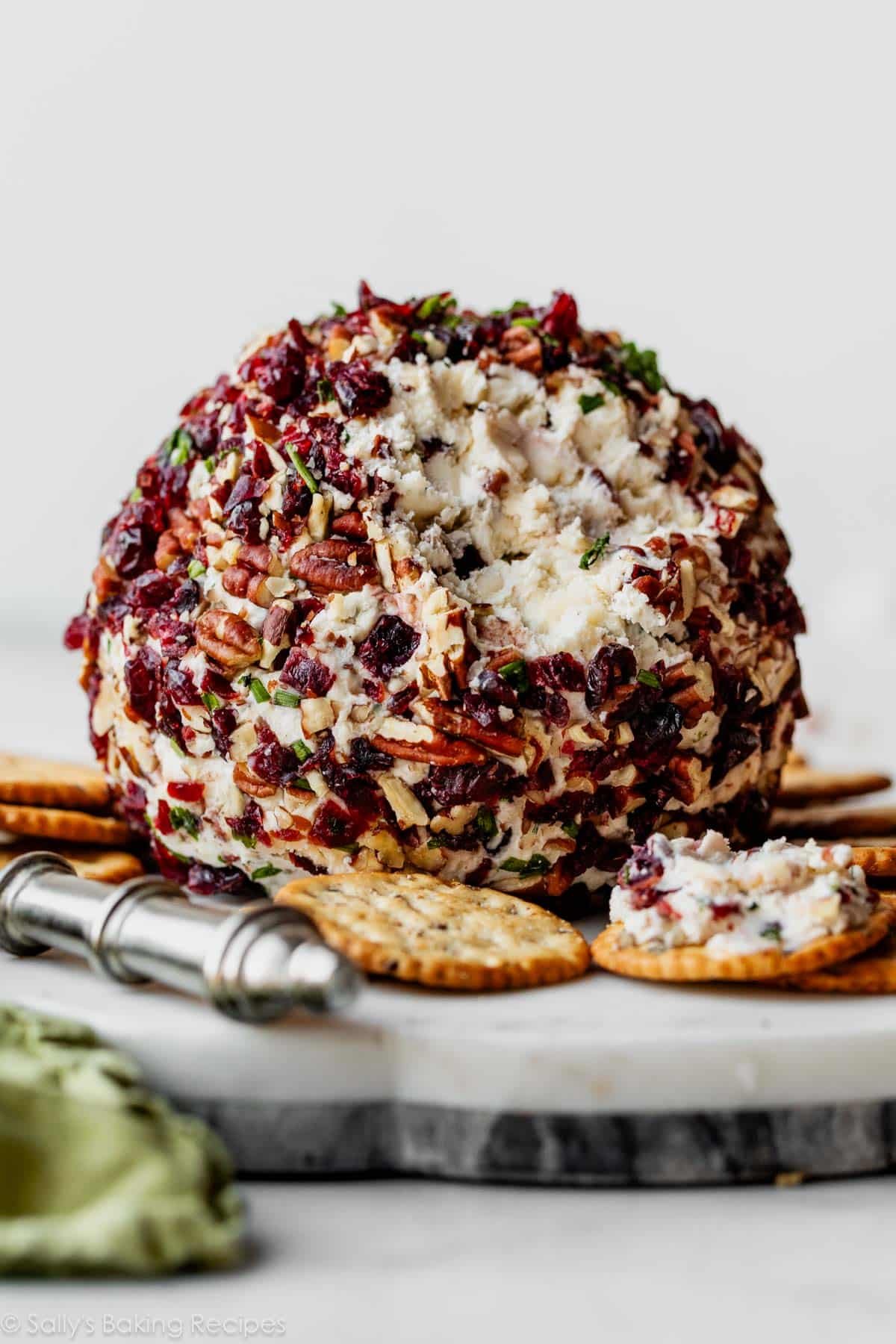 white cheddar cheese ball cut open and spread on cracker.