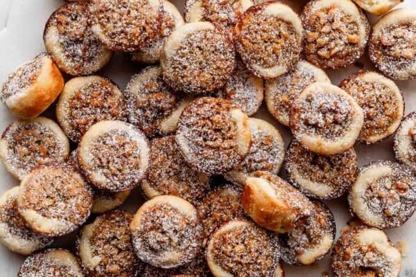 maple walnut tassies with sprinkle of confectioners' sugar on top.