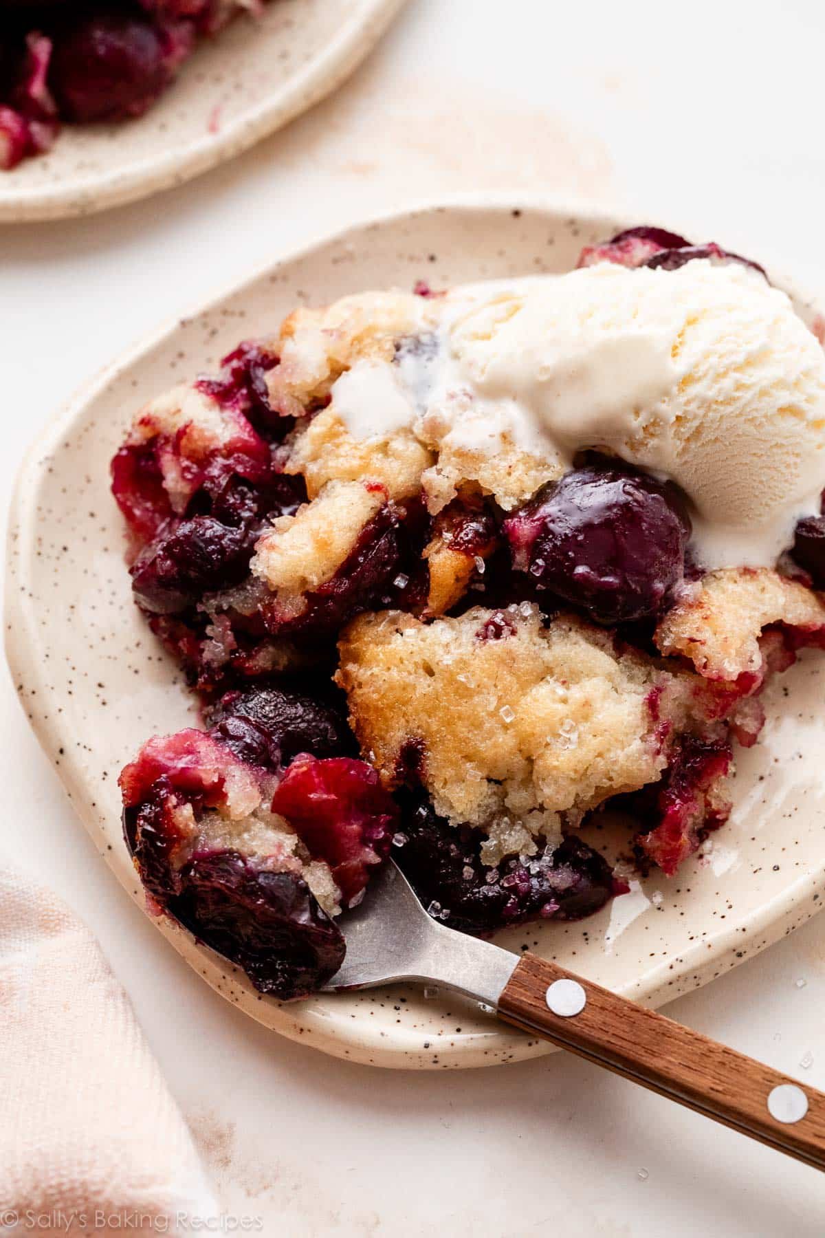 cherry cobbler with ice cream on plate.