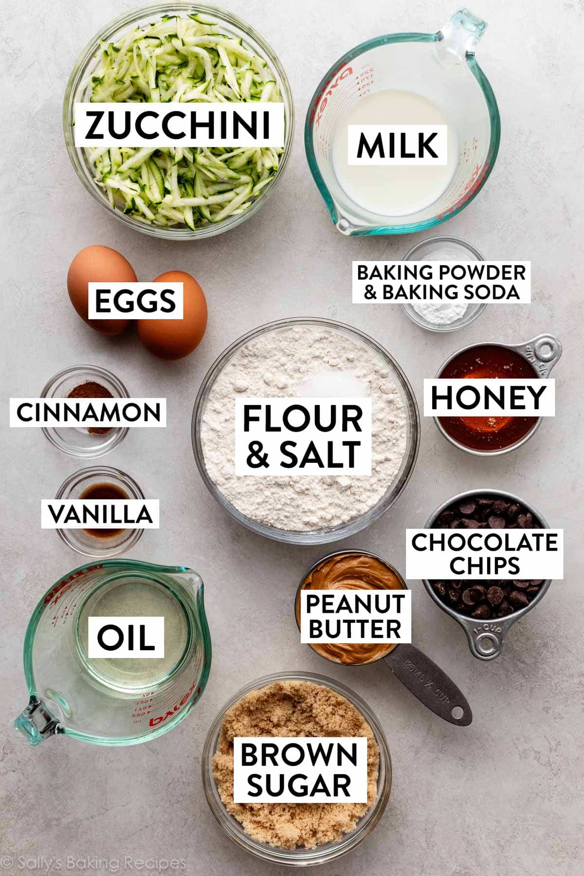 ingredients on counter including milk, flour, honey, chocolate chips, oil, eggs, cinnamon, and vanilla.